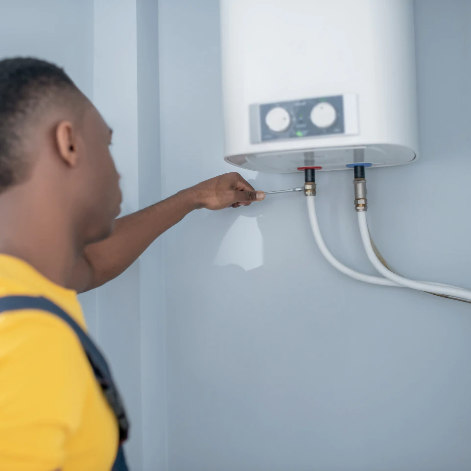 a person tightening the water heater hose